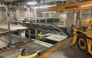 millwright team installation of vehicle pallet for mechanical parking system