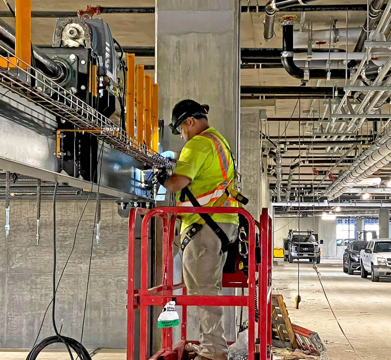 electrician installing energy and controls system in automated parking system with other building systems in vieew